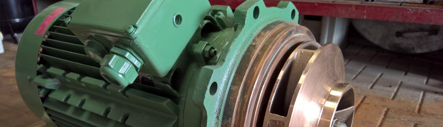 Nahaufnahme eines grünen Industriemotors mit sichtbarem Kupferrotor und Befestigungslöchern