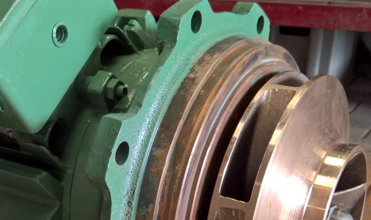 Nahaufnahme eines grünen Industriemotors mit sichtbarem Kupferrotor und Befestigungslöchern