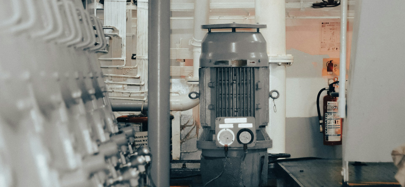 Industrielle Maschine mit Druckmessern in einer technischen Anlage, Feuerlöscher an der Wand im Hintergrund