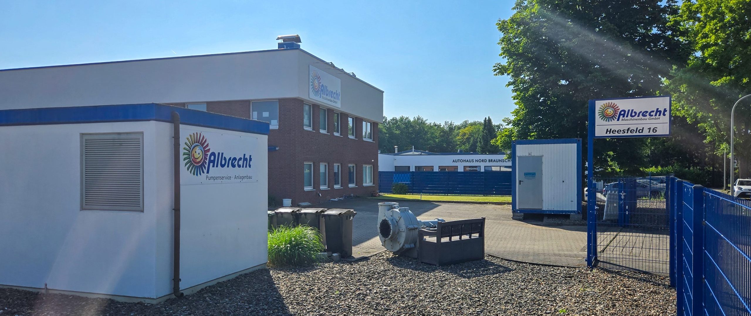 Firmengelände von Albrecht Pharmaprodukte Logistik mit Bürogebäude, Lagercontainern und Eingangstor mit Firmenschild