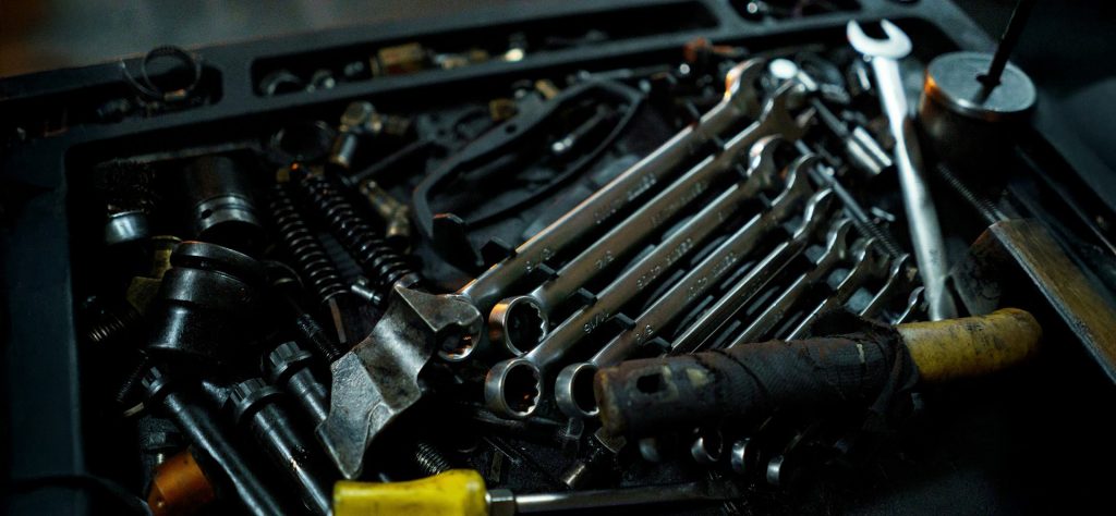 Offene Werkzeugkiste mit Schraubenschlüsseln, Zangen und weiteren Werkzeugen für Pumpentausch oder Reparatur