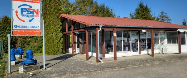 Gebäude mit Glasfront und rotem Dach, davor ein Schild mit Logo und Kontaktdaten von PSN Pumpenservice
