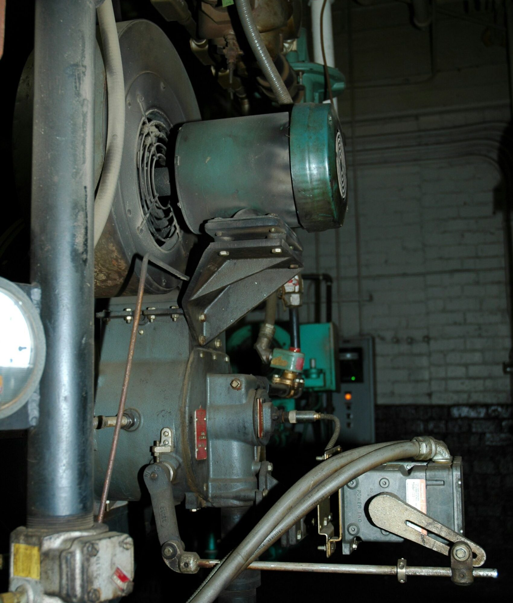 Industrielle Maschine mit Ventilator und Rohrleitungen in einer dunklen Fabrikumgebung